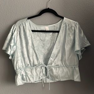 Blue floral print tie top. Some mild fabric pulls.